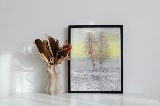 Two bare trees in a snowy field with a gray and yellow sky